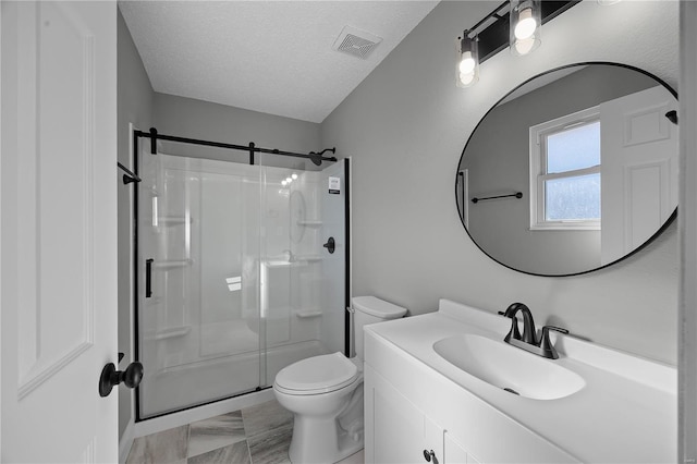 full bathroom featuring a stall shower, visible vents, a textured ceiling, and toilet