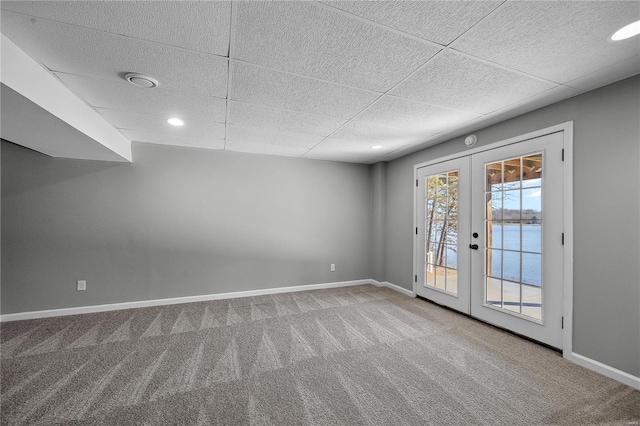 carpeted empty room with french doors, recessed lighting, a paneled ceiling, and baseboards