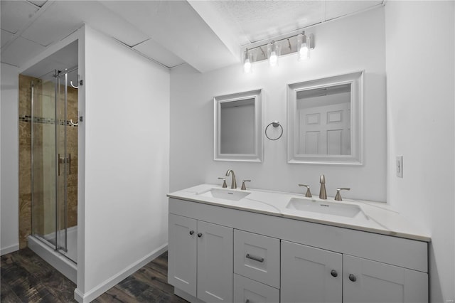 full bath with a shower stall, a sink, and wood finished floors