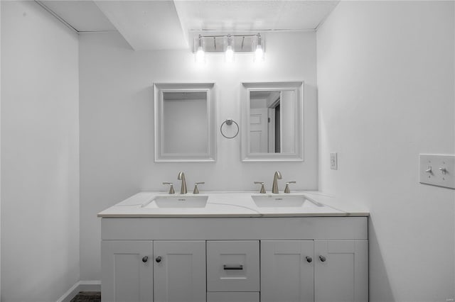 bathroom featuring a sink, baseboards, and double vanity