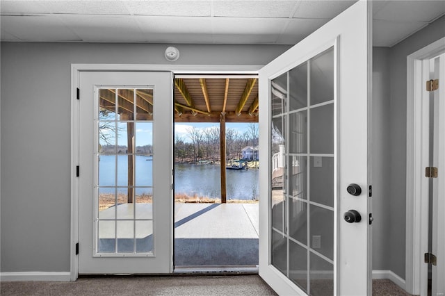 doorway with french doors, a water view, a drop ceiling, and baseboards