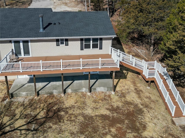 back of property with a shingled roof and a wooden deck