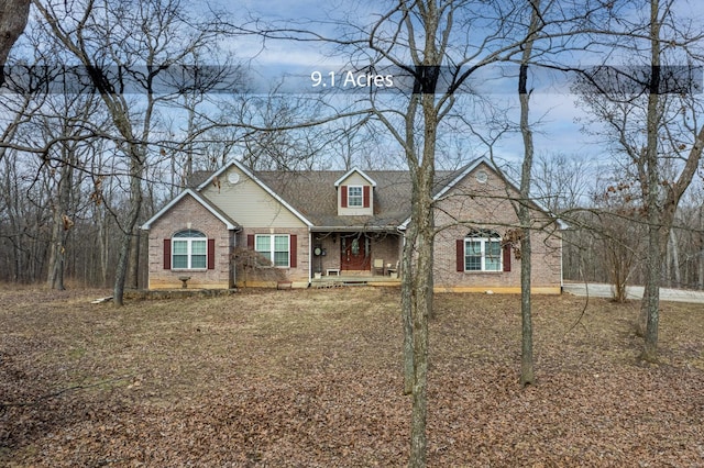 view of front facade featuring covered porch and brick siding