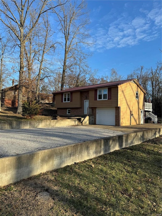 exterior space featuring a garage, brick siding, and aphalt driveway