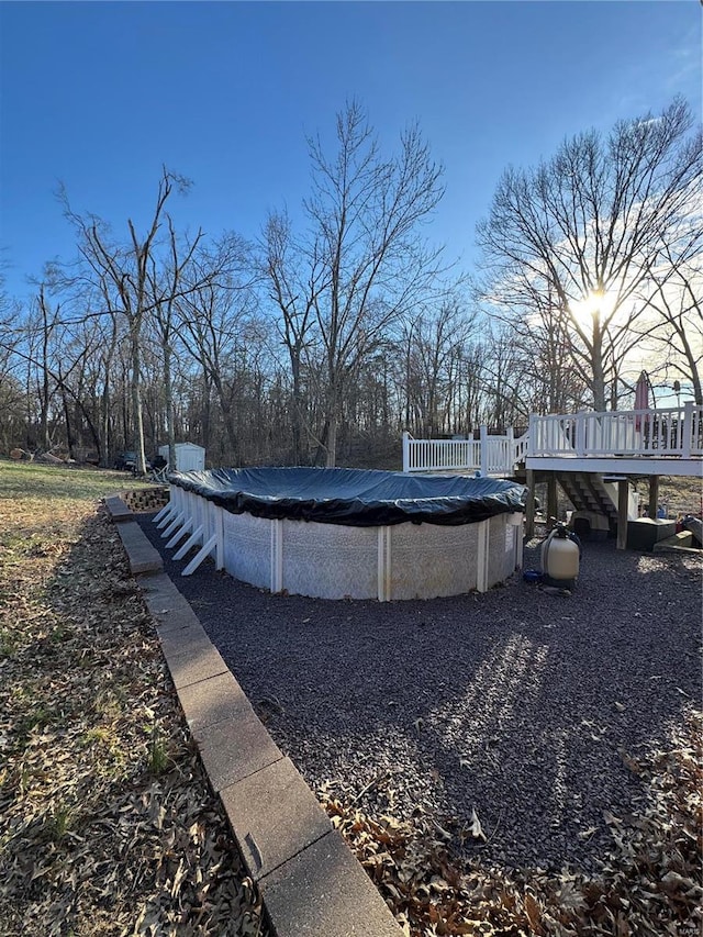 view of swimming pool with a covered pool and a deck