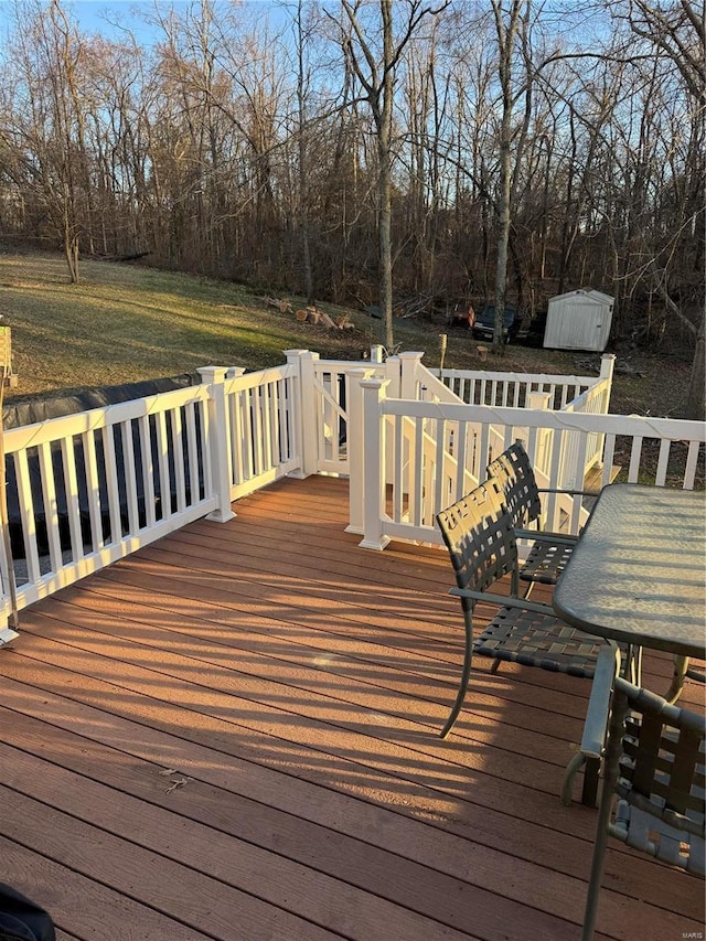 wooden terrace featuring an outbuilding and a storage unit