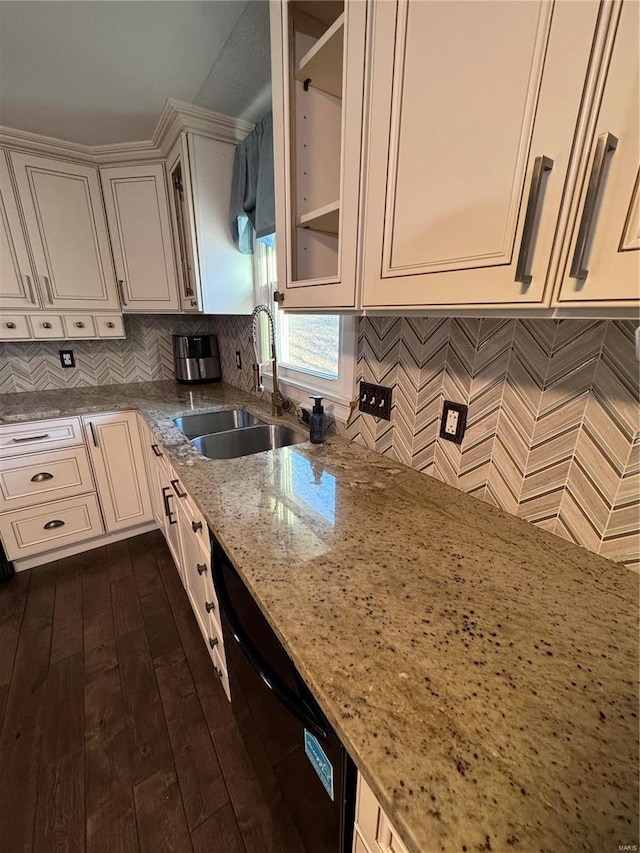 kitchen with black dishwasher, dark wood-style flooring, glass insert cabinets, a sink, and light stone countertops