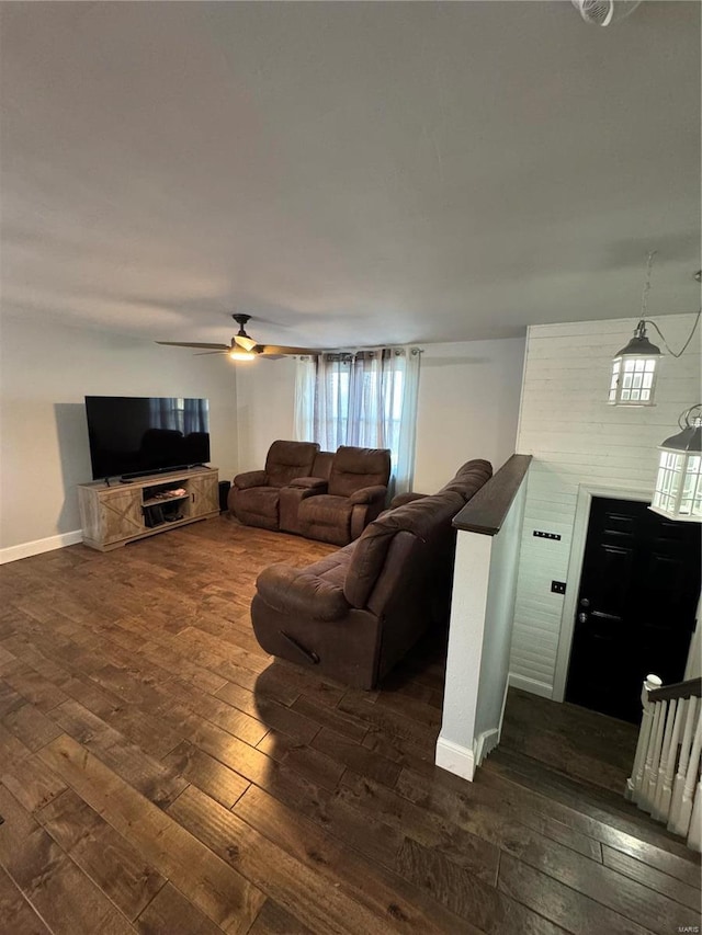 living area featuring dark wood-style floors, baseboards, and a ceiling fan