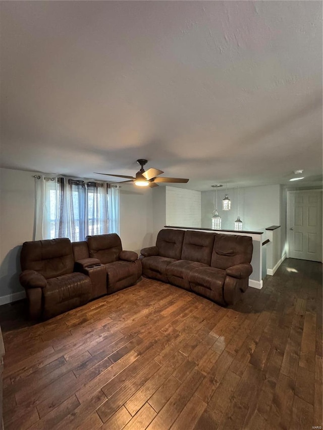 living area with dark wood-style floors, ceiling fan, and baseboards