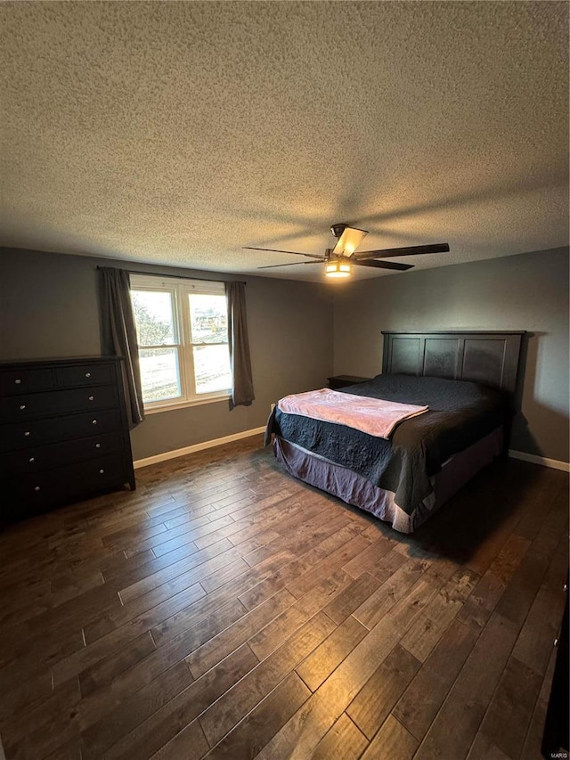 bedroom with dark wood-type flooring, a textured ceiling, and baseboards