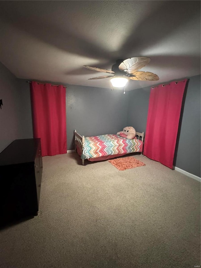 bedroom featuring ceiling fan, a textured ceiling, baseboards, and carpet flooring