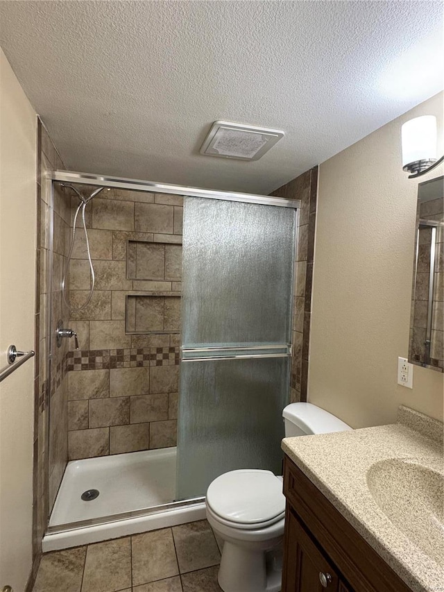 bathroom featuring a stall shower, visible vents, vanity, and toilet