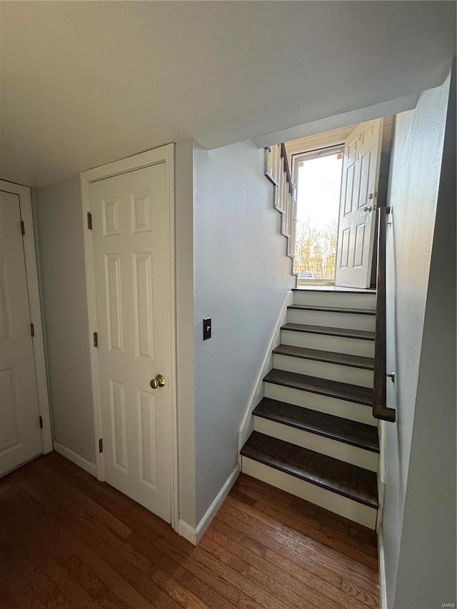 stairway featuring wood finished floors and baseboards