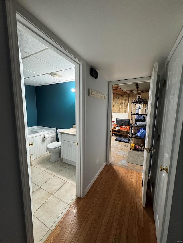 corridor with baseboards and light wood-style floors