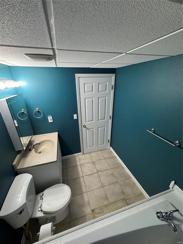 bathroom with toilet, vanity, baseboards, and tile patterned floors