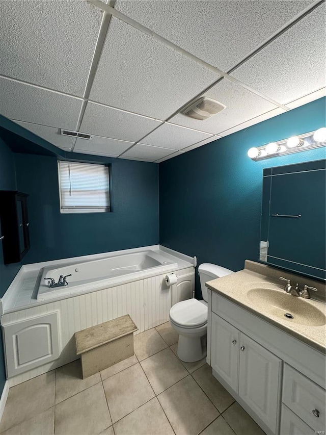 bathroom with a garden tub, visible vents, toilet, vanity, and a drop ceiling