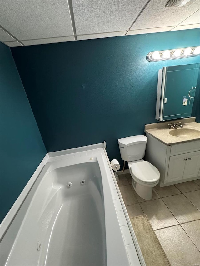 full bathroom with a paneled ceiling, a jetted tub, toilet, and vanity