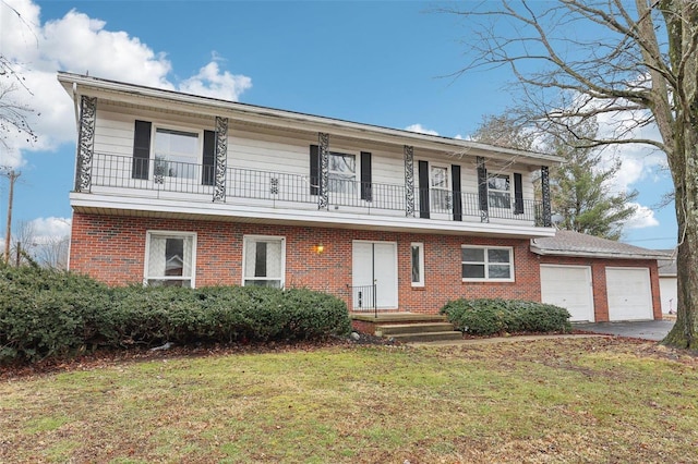 view of front of home with an attached garage, a balcony, brick siding, driveway, and a front lawn