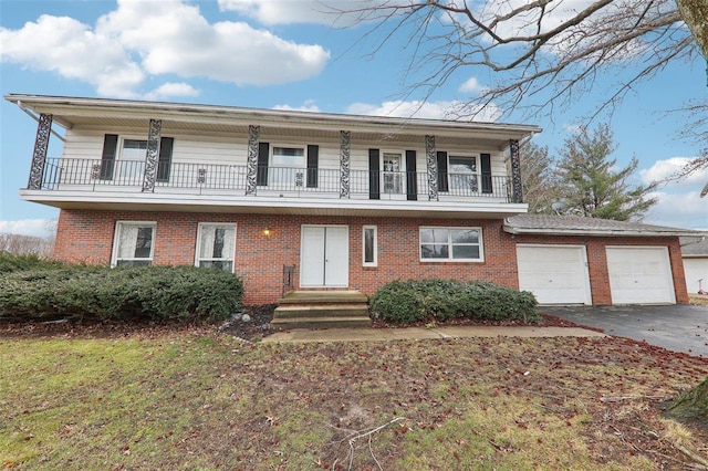 view of front of property featuring a balcony, driveway, an attached garage, and brick siding