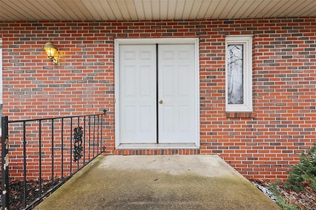 entrance to property featuring brick siding