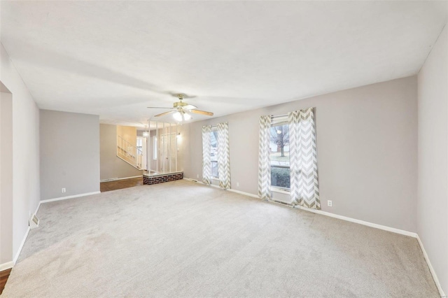 carpeted empty room with ceiling fan and baseboards