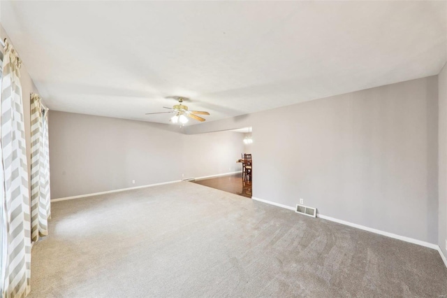 spare room featuring carpet, visible vents, ceiling fan, and baseboards