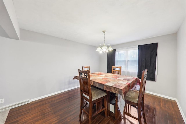 dining area featuring a chandelier, baseboard heating, baseboards, and wood finished floors