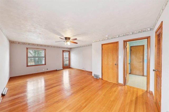 spare room with ceiling fan, light wood-type flooring, and visible vents