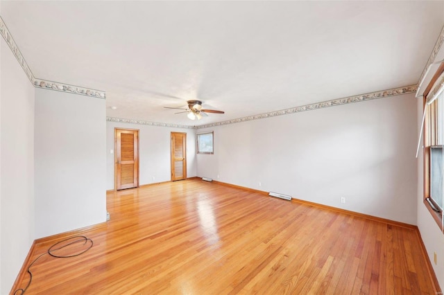 empty room featuring a ceiling fan, baseboards, visible vents, and light wood finished floors