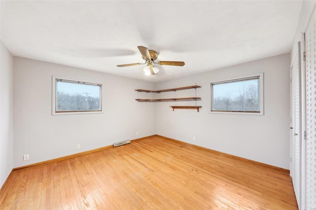 spare room with ceiling fan, visible vents, light wood-style flooring, and baseboards