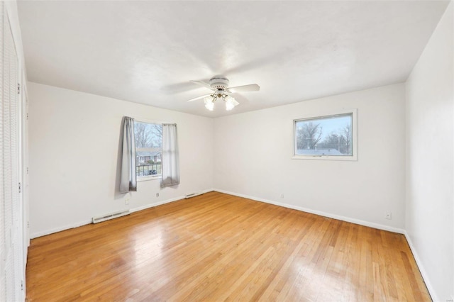 empty room featuring baseboards, light wood-type flooring, visible vents, and a ceiling fan