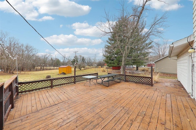 deck with an outbuilding, a yard, and a storage shed