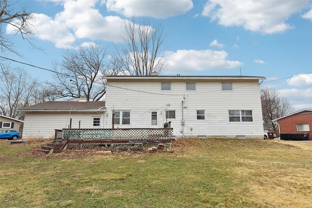 back of property featuring a deck and a lawn