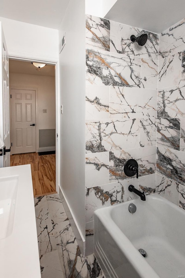 full bathroom featuring visible vents, baseboards, tub / shower combination, a sink, and marble finish floor