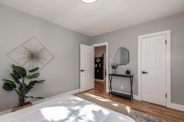 bedroom with baseboards and wood finished floors