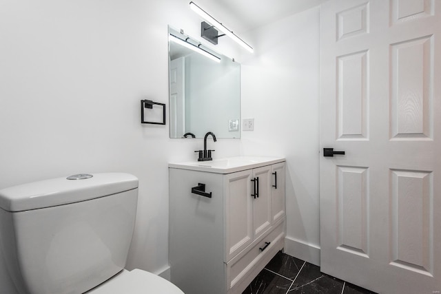 half bath featuring vanity, toilet, baseboards, and marble finish floor