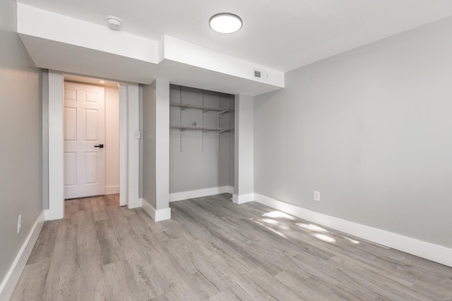 unfurnished bedroom featuring visible vents, baseboards, light wood-style floors, and a closet