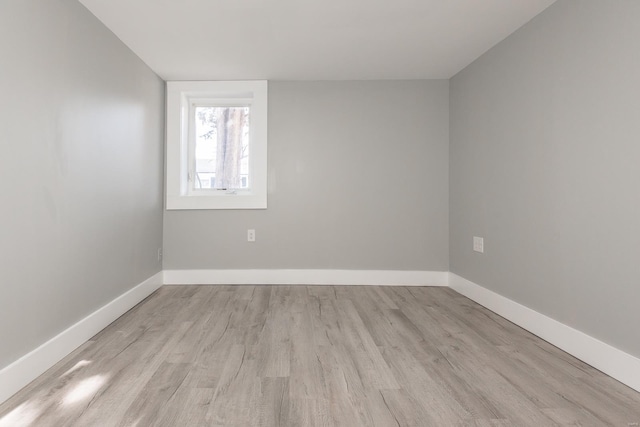 empty room with baseboards and wood finished floors