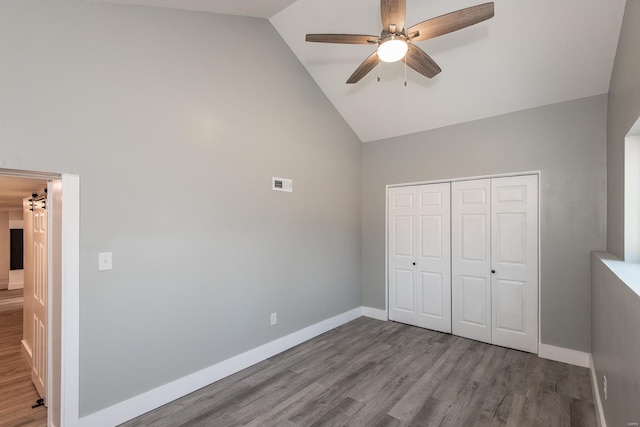 unfurnished bedroom with a closet, visible vents, baseboards, and wood finished floors