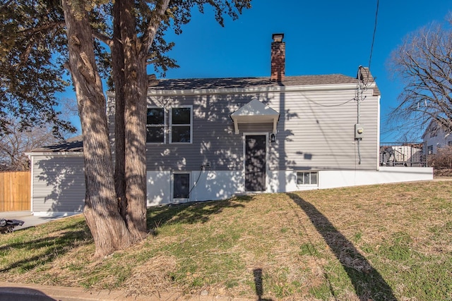 view of front of home featuring a chimney, a front lawn, and fence