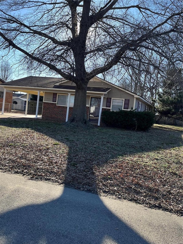 view of front facade with a carport and brick siding