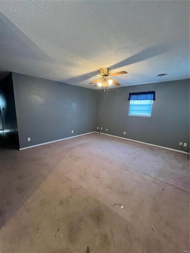 empty room featuring ceiling fan, baseboards, and a textured ceiling