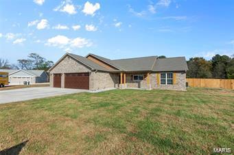 view of front of home featuring an attached garage, fence, concrete driveway, and a front yard