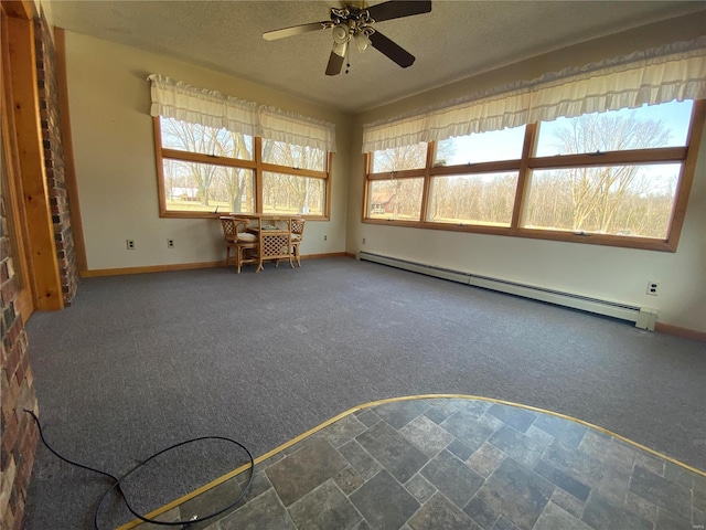 interior space with a baseboard radiator, baseboards, a textured ceiling, and a ceiling fan