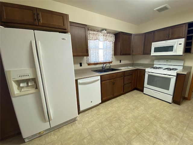 kitchen with visible vents, white appliances, light countertops, and a sink