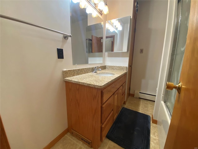 full bathroom with a baseboard heating unit, bath / shower combo with glass door, vanity, and tile patterned flooring