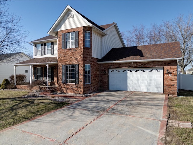 traditional home with concrete driveway, an attached garage, fence, a front lawn, and brick siding