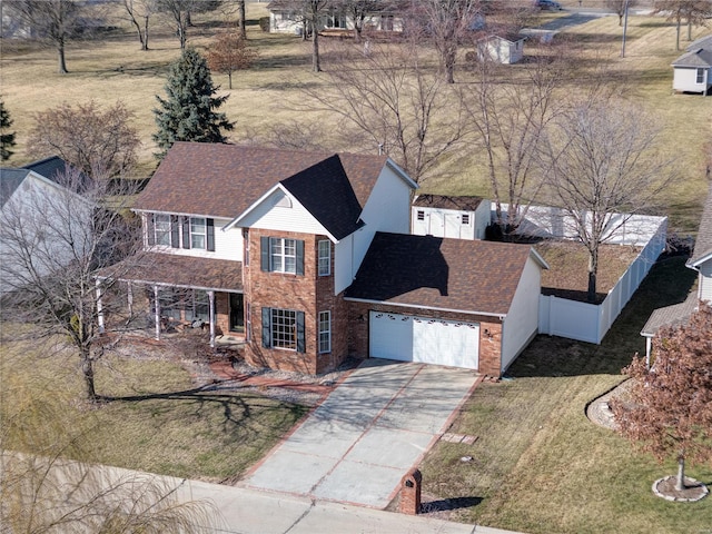 view of front of house with a garage, brick siding, fence, driveway, and a front lawn