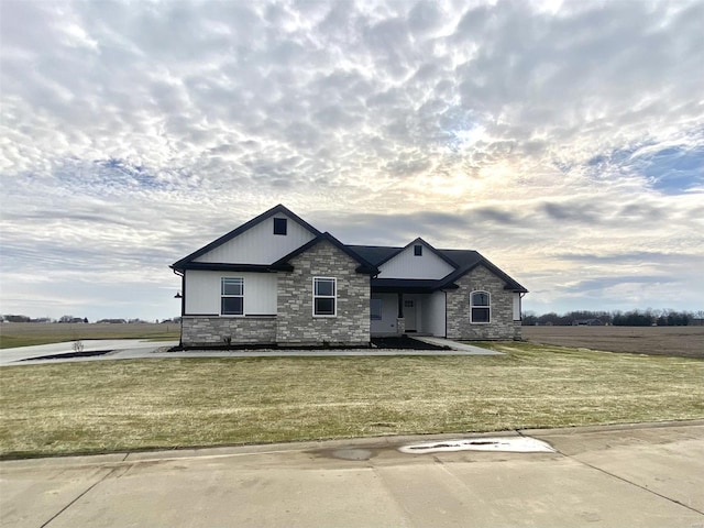 view of front of home with a front yard and stone siding