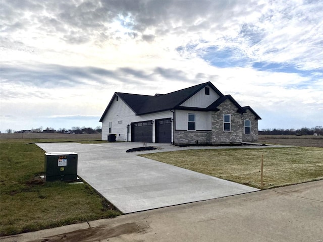 view of front of home with a garage, stone siding, driveway, and a front lawn